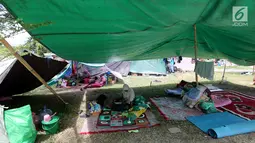 Pengungsi korban gempa dan tsunami Palu beristirahat di tenda pengungsian lapangan Walikota Palu, Sulawesi Tengah, Senin (8/10). Nantinya, pemerintah akan memindahkan pengungsi yang masih bertahan di tenda ke barak pengungsian. (Liputan6.com/Fery Pradolo)