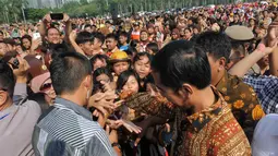 Pria yang akrab disapa Jokowi itu tiba pukul   09.00 WIB dan langsung diserbu ratusan siswa   peserta upacara dari tingkat SD hingga SMA   se-DKI Jakarta, Kamis (14/8/14).  (Liputan6.com/Herman Zakharia) 