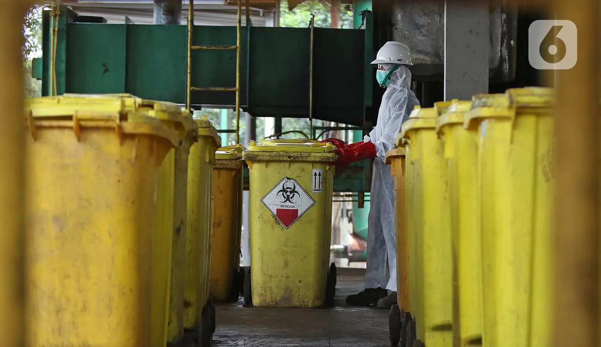 Petugas membawa "Wheeled Bin" atau tempat sampah berisi limbah B3 medis Infeksius Covid-19 untuk dimusnahkan di PT Jasa Medivest, Karawang, Jawa Barat, Kamis (10/12/2020).  PT Jasa Medivest telah memusnahkan lebih dari 500 ton limbah B3 medis dari Maret - Oktober 2020. (Liputan6.com/Herman Zakharia)