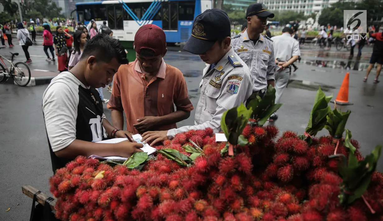 Petugas Dinas Perhubungan melakukan penindakan tegas terhadap pedagang yang berjualan di Car Free Day (CFD) di kawasan Bunderan HI, Jakarta, Minggu (4/2). (Liputan6.com/Faizal Fanani)