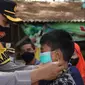 Kapolres Pemalang AKBP Ari Wibowo memakaikan masker ke anak yang tengah berkunjung ke objek wisata. (Foto: Liputan6.com/Humas Polres Pemalang)