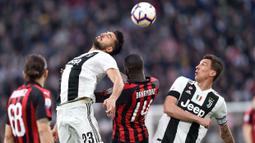 Gelandang Juventus, Emre Can, duel udara dengan gelandang AC Milan, Tiemoue Bakayoko, pada laga Serie A di Stadion Allianz, Turin, Sabtu (6/4). Juventus menang 2-1 atas AC Milan. (AP/Andrea Di Marco)