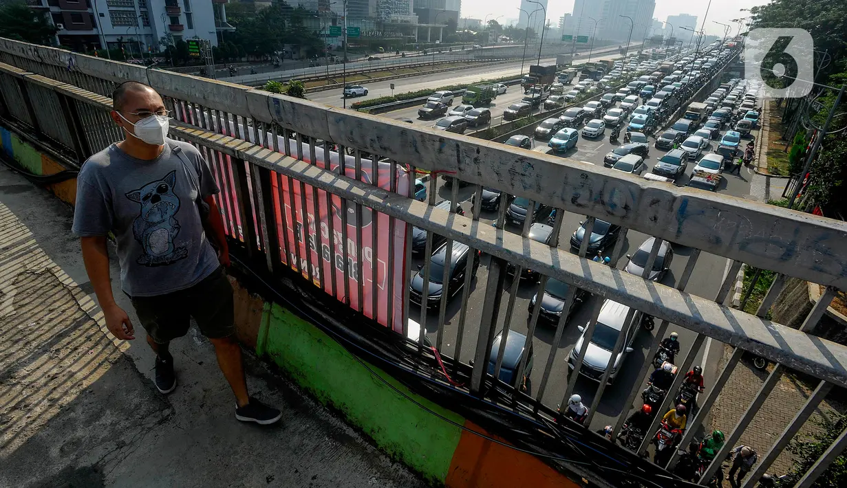 <p>Pejalan kaki yang mengenakan masker berjalan di atas jembatan penyeberangan orang (JPO) dengan arus lalu lintas yang macet di kawasan Jalan TB Simatupang, Jakarta, Rabu (15/8/2023). Kementerian Lingkungan Hidup dan Kehutanan (KLHK) menilai, sumber pencemaran kualitas udara alias polusi udara Jakarta dan sekitarnya masih didominasi oleh sektor transportasi. (merdeka.com/Arie Basuki)</p>