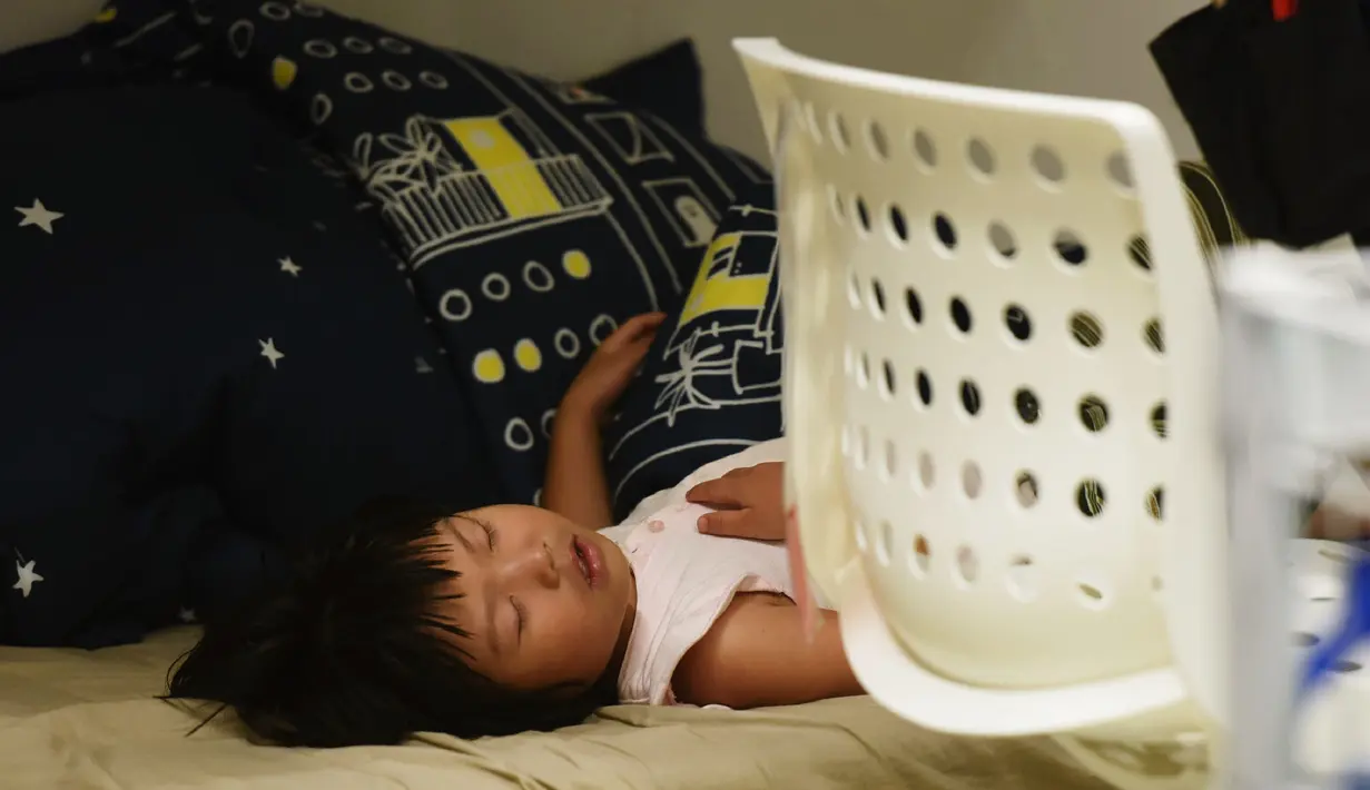 Seorang anak tidur di sebuah pusat perbelanjaan menghindari panas di luar di Hangzhou, di provinsi Zhejiang timur China (24/7). Beberapa pekan terakhir China mengalami suhu udara yang cukup panas. (AFP Photo/Str/China Out)