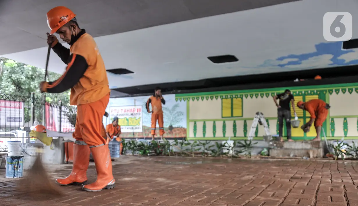 Petugas Penanganan Prasarana dan Sarana Umum (PPSU) Kelurahan Bali Mester menyapu saat menyelesaikan pembangunan taman bermain di kolong Flyover Kampung Melayu, Jakarta, Selasa (7/3/2023). Pembangunan taman bermain tersebut bertujuan mengubah kolong flyover yang sebelumnya terkesan seram menjadi tempat interaksi warga sekitar sekaligus penataan kawasan. (merdeka.com/Iqbal S. Nugroho)