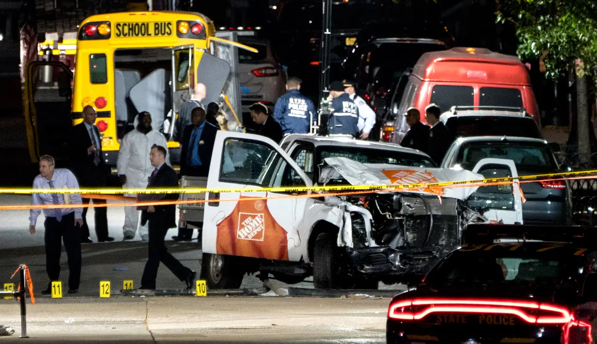 Petugas keamanan berdiri dekat sebuah truk dari Home Depot yang menabrak pejalan kaki dan pesepeda di dekat World Trade Center (WTC), New York, Selasa (31/10). Kepolisian Amerika Serikat menyebut insiden ini sebagai serangan teror. (AP/Craig Ruttle)