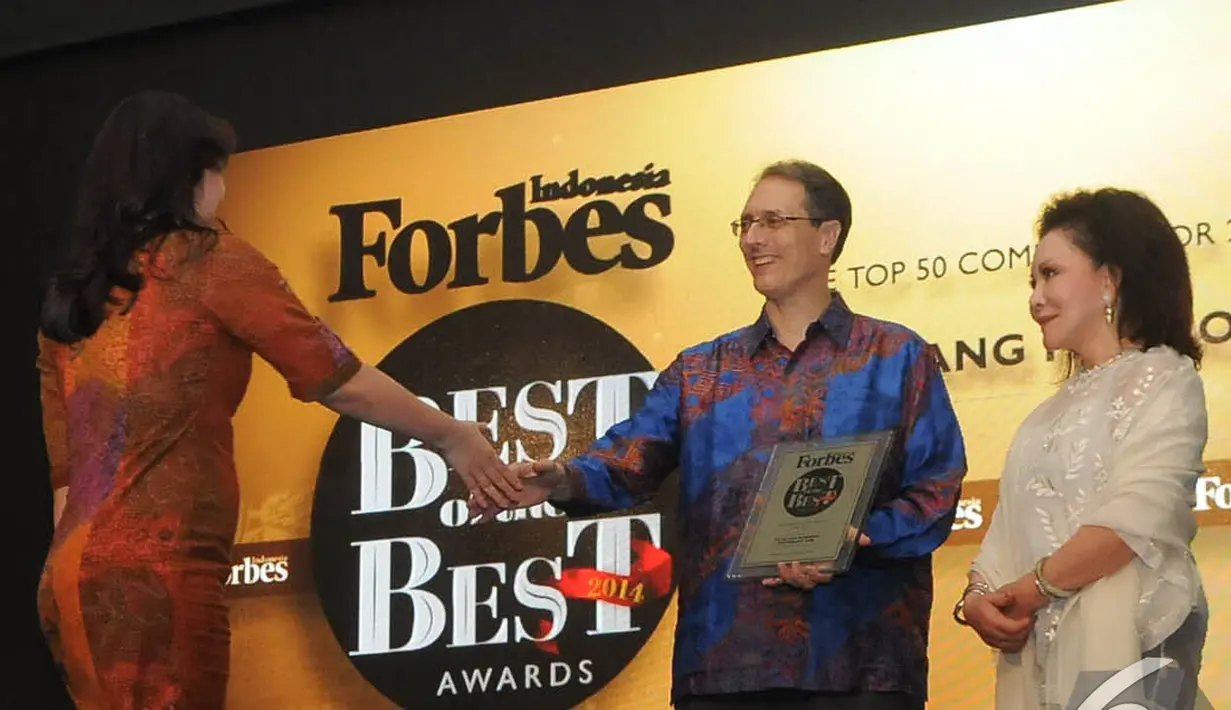 Perwakilan PT Elang Mahkota Tekhnologi Tbk maju ke panggung untuk menerima penghargaan dari Majalah Forbes Indonesia, Hotel Ritz Carlton, Mega Kuningan, Jakarta, Rabu (10/12/2014). (Liputan6.com/Herman Zakharia)