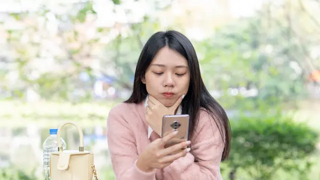 Seorang perempuan menggunakan ponsel