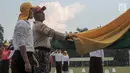 Pelatih mengajarkan melipat bendera kepada calon Paskibraka di PPPON, Cibubur, Jakarta, Senin (31/7). Memasuki hari ke-7, calon Paskibraka matangkan latihan menaikan bedera. (Liputan6.com/Yoppy Renato)