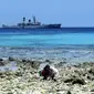 Bocah bermain di Pantai dengan latar belakang KRI Yos Sudarso 353 saat berlabuh di Miangas, Sulut. KRI tersebut memantau keamanan pulau terluar Indonesia yang berbatasan Filipina.(Antara)