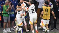 Pemain Jerman merayakan gol yang dicetak Niclas Fullkrug dalam menit akhir pertandingan melawan Swiss di Grup A Euro 2024 yang digelar di Frankfurt Arena, Senin (24/6/2024) dini hari WIB. Jeman dan Swiss bermain imbang 1-1 dan sama-sama lolos ke 16 besar Euro 2024. (Kirill KUDRYAVTSEV / AFP)
