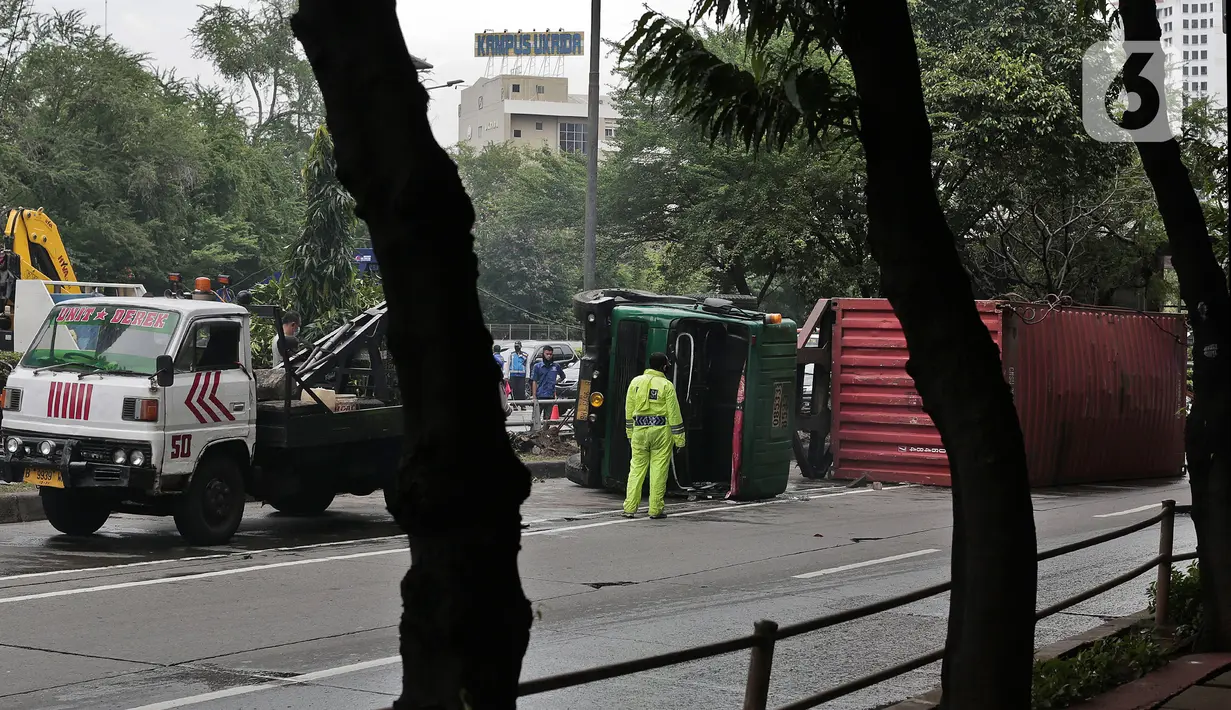 Petugas melakukan evakuasi Kontainer yang terguling di Jalan S Parman, Jakarta Barat, Senin (4/5/2020). Tidak ada korban jiwa dalam kecelakaan tersebut, namun kecelakaan tersebut membuat lalin dijalan itu terimbas kemacetan yang cukup panjang. (Liputan6.com/Johan Tallo)