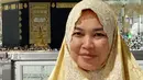 Bisa berfoto di depan Ka’bah wajah ibunda Ayu Ting Ting sangat berbahagia. Terlihat senyum semringah di wajah umi Kalsum yang memakai hijab berwarna kuning. (Instagram/mom_ayting92_)