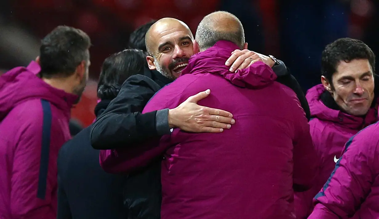 Pep Guardiola (tengah) melakukan selebrasi dengan pemainnya usai pertandingan melawan Manchester United di Liga Inggris di Old Trafford Stadium, Inggris, (10/12). Usai mengalahkan MU, City kokoh di puncak klasemen dengan poin 46. (AP Photo/Dave Thompson)