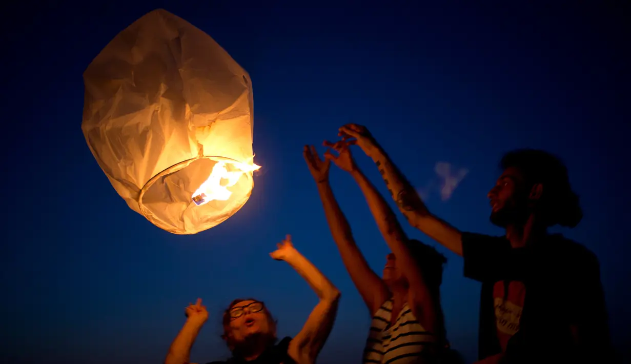 Sejumlah aktivis menerbangkan lentera untuk menerangi langit Gaza di pantai Ashkelon, Israel, (19/6). Aksi tersebut sebagai protes terhadap pengurangan pasokan listrik ke Gaza oleh pemerintah Israel. (AP Photo / Ariel Schalit)