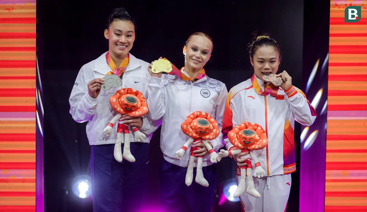 <p>Pesenam asal Russia sekaligus peraih medali emas, Angelina Melnikova (tengah) berfoto bersama pesenam Amerika Serikat sekaligus peraih medali perak, Leanne Wong (kiri) dan pesenam China sekaligus peraih medali perunggu, Zhang Qingying pada podium kategori All-Around putri Kejuaraan Dunia Gimnastik 2025 di Indonesia Arena, Senayan, Jakarta, Kamis (23/10/2025). (Bola.com/Bagaskara Lazuardi)</p>