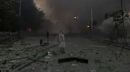 Seorang pria berdiri di tengah kepulan asap dan melihat bangunan-bangunan yang rusak parah akibat serangan Rusia di Kyiv pada Minggu 24 Mei 2026, di tengah invasi Rusia ke Ukraina. (Roman PILIPEY/AFP)
