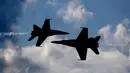 Dua pesawat Blue Angels dari Angkatan Laut AS saling berpapasan dengan kecematan tinggi saat melakukan aksinya di Brunswick, Maine (26/8). (AP Photo / Robert F. Bukaty)