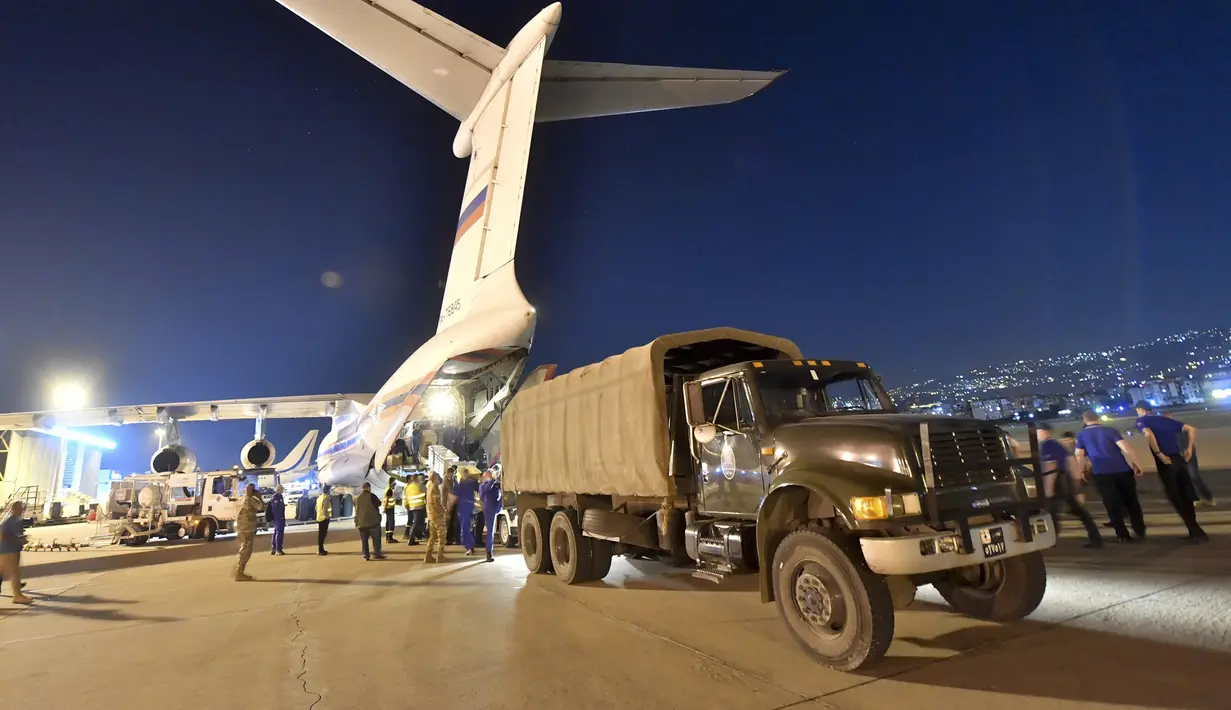 Para pekerja membongkar kotak pasokan bantuan Rusia dari pesawat kargo Rusia ke truk di sebuah bandara di Beirut, Lebanon, Rabu (5/8/2020). Rusia mengirim lima paket bantuan ke Lebanon setelah ledakan besar di Pelabuhan Beirut. (AP Photo/Ministry of Emergency Situations press service via AP)