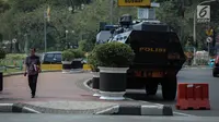 Pejalan kaki melintas di samping kendaraan taktis milik Brimob yang disiagakan di sekitar bundaran Patung Kuda, Jakarta, Jumat (28/7). Kendaraan taktis disiapkan untuk mengamankan aksi 287 yang digelar Presidium Alumni 212. (Liputan6.com/Faizal Fanani)