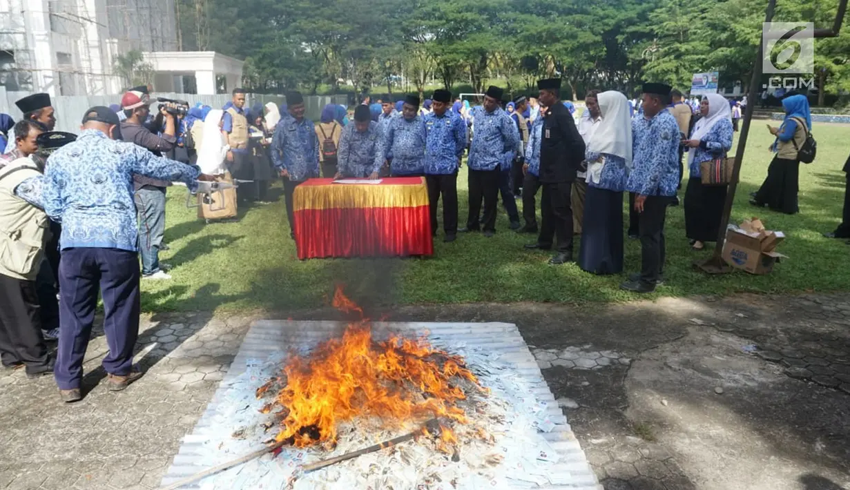 Petugas membakar KTP Elektronik yang rusak untuk dimusnahkan di halaman Kantor Bupati Bone Bolango (Bonebol), Gorontalo, Selasa (18/12). Pemusnahan e-KTP yang rusakini disaksikan langsung oleh Bupati Bone Bolango, Hamim Pou. (Liputan6.com/Arfandi Ibrahim)