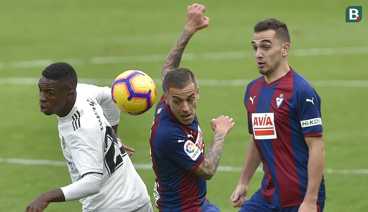Striker Real Madrid, Vinicius Junior, berebut bola dengan gelandang Eibar, Ruben Pena, pada laga La Liga di Stadion Ipurua, Eibar, Sabtu (24/11). Eibar menang 3-0 atas Madrid. (AFP/Ander Gillenea)