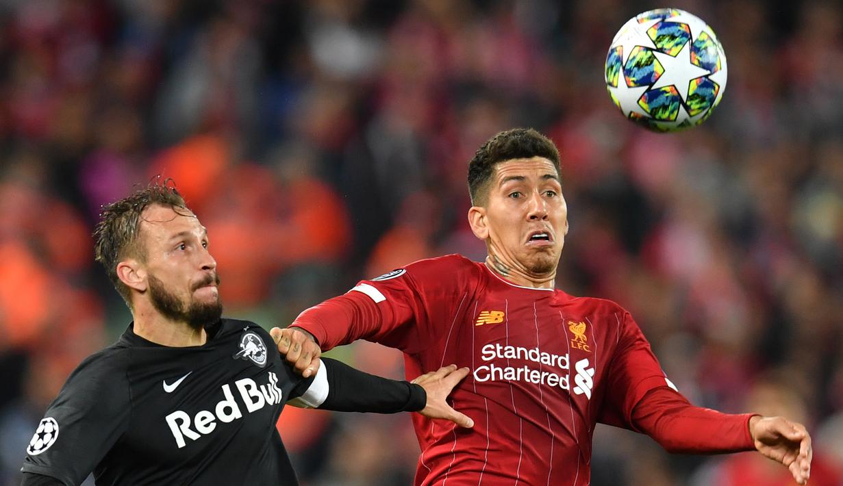 Gelandang Liverpool, Roberto Firmino, duel udara dengan bek Salzburg, Andreas Ulmer, pada laga Liga Champions di Stadion Anfield, Liverpool, Rabu (2/10). Liverpool menang 4-3 atas Salzburg. (AFP/Paul Ellis)