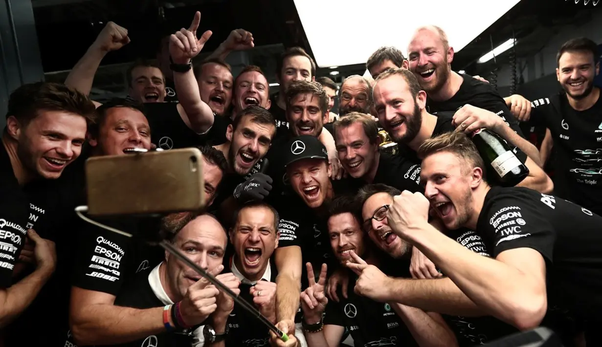 Pebalap Mercedes, Nico Rosberg, berselfie ria bersama kru Mercedes seusai menang pada balapan F1 GP Jepang di Sirkuit Suzuka, Minggu (9/10/2016). (AFP/Behrouz Mehri)