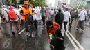 Dua petugas kebersihan DKI Jakarta membersihkan sampah usai aksi damai 2 Desember di kawasan Jalan MH Thamrin, Jakarta, Jumat (2/12). Aksi damai 2 Desember digelar sebagai lanjutan dari aksi 4 November 2016. (Liputan6.com/Ferbian Pradolo)