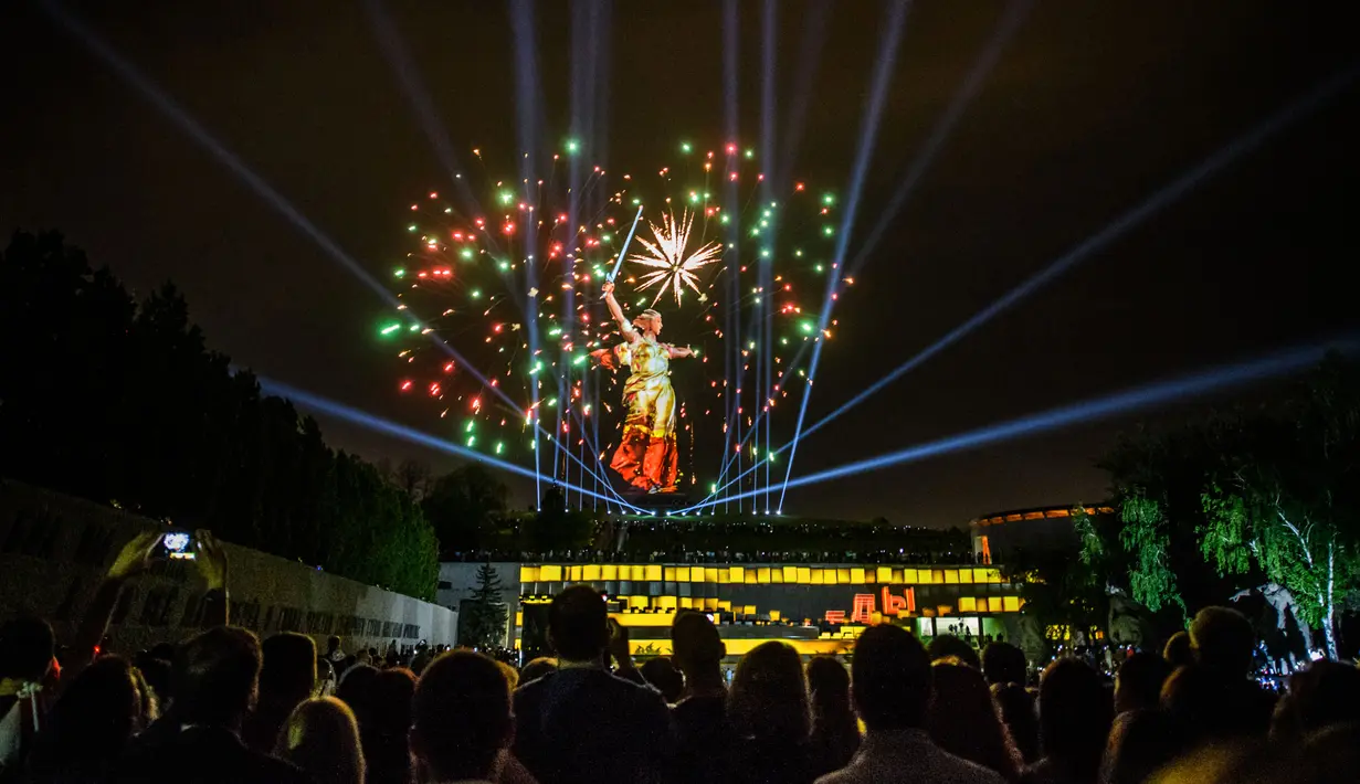 Sejumlah orang menyaksikan kembang api yang menghiasi patung The Motherland Calls saat perayaan 73 tahun kemenangan Rusia dalam Perang Dunia II di Volgograd (8/5). (AFP/Mladen Antonov)