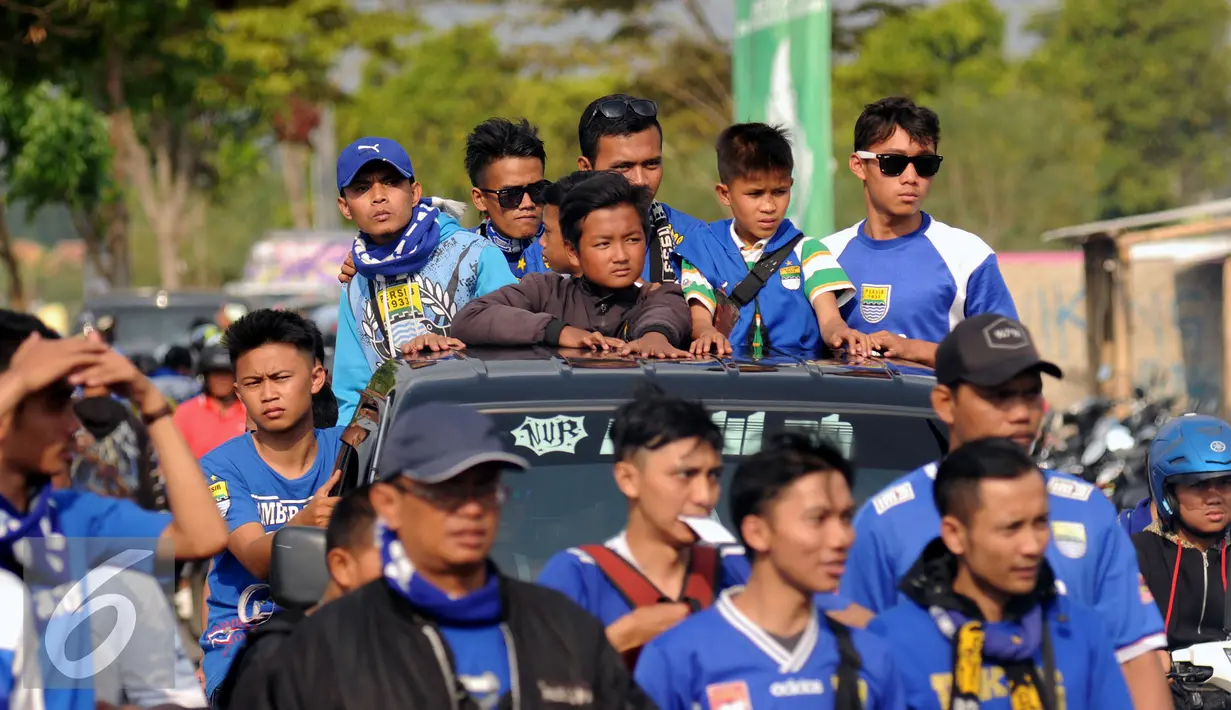 Sejumlah suporter menggunakan kendaraan bak terbuka menuju Stadion Si Jalak Harupat untuk menyaksikan laga Persib melawan PBFC, Bandung, Sabtu (26/9/2015). Persib unggul 2-1 dan lolos ke Semifinal Piala Presiden 2015. (Liputan6.com/Helmi Fithriansyah)
