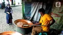 Warga memperhatikan pembuatan dodol Betawi di Setu Babakan, Jagakarsa, Jakarta Selatan, Minggu (4/4/2021). Kios yang boleh dibuka bergantian dengan sistem tanggalan ganjil genap. (merdeka.com/Arie Basuki)
