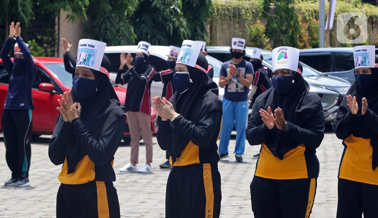 Mahasiswi Politeknik Kesehatan Jakarta III bertepuk tangan selama 56 detik pada Hari Kesehatan Nasional ke-56 di Jatiwarna, Bekasi, Jawa Barat, Kamis (12/11/2020). Kegiatan tersebut merupakan bentuk apresiasi terhadap tenaga medis yang berjuang selama pandemi COVID-19. (Liputan6.com/Herman Zakharia)