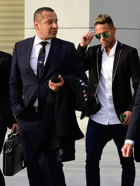 Neymar (tengah) bersama ayahnya (kanan) tiba di pengadilan nasional Spanyol di Madrid (2/2). Neymar dipanggil untuk memberikan bukti atas transfer dirinya dari Santos ke Barcelona pada tahun 2013. (AFP PHOTO/AVIER Soriano)