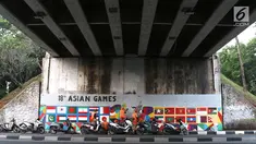 Petugas PPSU Srengseng Sawah menggambar mural bertema Asian Games 2018 di kolong flyover Universitas Indonesia, Depok, Jawa Barat, Jumat (27/7). Mural dibuat dalam rangka menyambut perhelatan Asian Games 2018. (Liputan6.com/Immanuel Antonius)