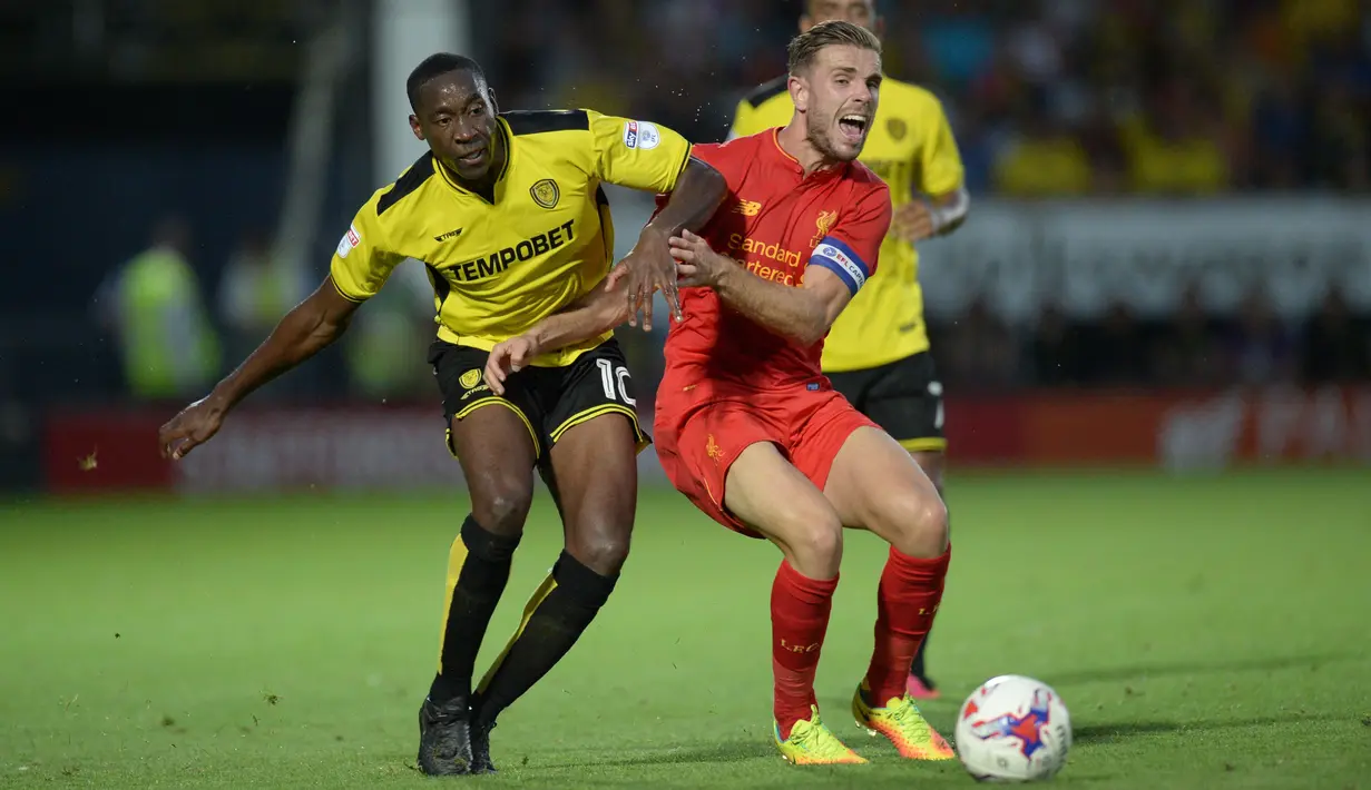 Pemain Burton Albion, Lucas Akins (kiri) menghadang pemain Liverpool, Jordan Henderson pada putaran kedua piala Liga Inggris di Pirelli Stadium, Burton-on-Trent, (24/8/2016) dini hari WIB.  (AFP/Oli Scarf)