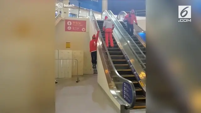 Ada-ada saja yang dilakukan pria ini untuk melewati eskalator, yaitu dengan bergelantungan.
