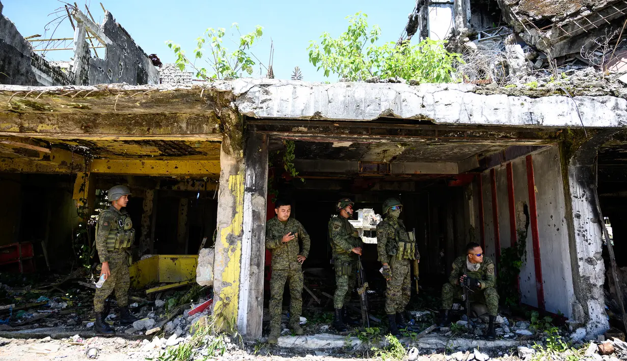 Tentara berkumpul di sebuah bangunan yang hancur di Kota Marawi, Provinsi Lanao del Sur, Filipina, Kamis (23/5/2019). Sebanyak 165 tentara, 45 warga sipil, dan ratusan gerilyawan ISIS tewas dalam konflik lima bulan di Kota Marawi. (Noel CELIS/AFP)