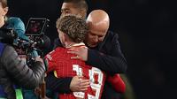 Gelandang Liverpool, Harvey Elliot dipeluk sang manajer, Arne Slot. Elliot mencetak gol kemenangan Liverpool atas PSG pada leg pertama 16 besar Liga Champions 2024/2025 di Parc des Princes, Paris, Kamis (6/3/2025) dini hari WIB. (Frank Fife/AFP)