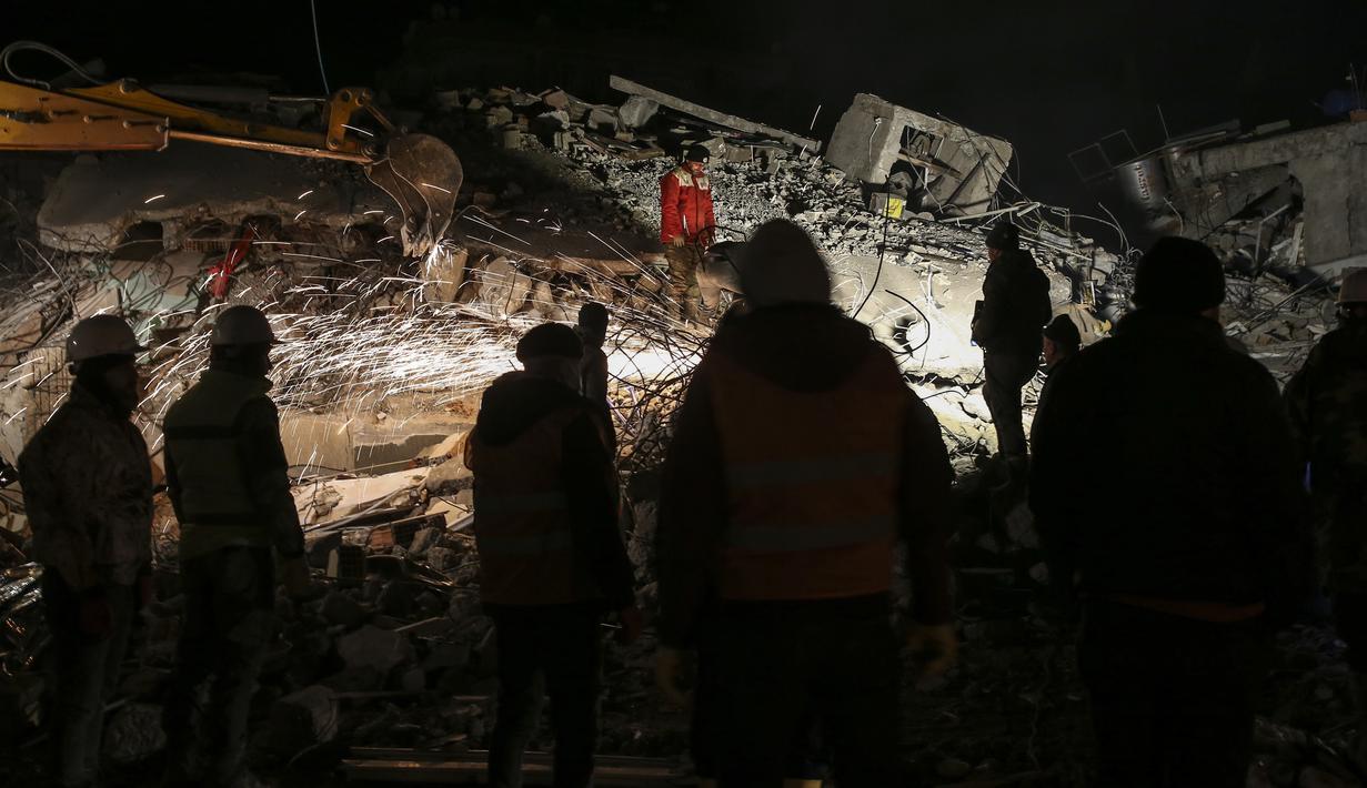 Tim penyelamat mencari korban gempa Turki di sebuah bangunan yang hancur, di Adiyaman, tenggara Turki, Rabu, 8 Februari 2023. Korban tewas yang dikonfirmasi dari gempa paling mematikan di dunia dalam satu dekade lebih mendekati 12.000. (AP Photo/Emrah Gurel)