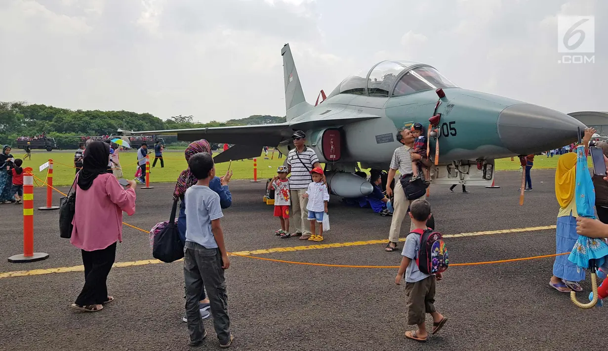 Warga foto di dekat jet tempur TNI AU saat pesta rakyat peringatan HUT TNI AU ke-72 di Lanud Halim Perdanakusumah, Jakarta, Sabtu (7/4). Pesta rakyat tersebut dilaksanakan untuk mendekatkan masyarakat dengan TNI AU. (Liputan6.com/Herman Zakharia)