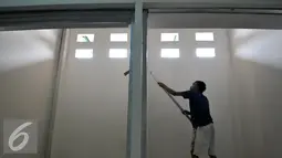 Pekerja menyelesaikan pengecatan kios di TPS Pasar Rumput, Manggarai, Jakarta Selatan, Jumat (26/8). (Liputan6.com/Yoppy Renato)