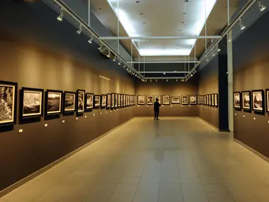 Pengunjung menikmati deretan foto bertema Melampaui Fotografi karya Suherry Arno di Galeri Nasional, Jakarta, Selasa (24/10). Pameran foto tunggal karya Suherry Arno ini berlangsung hingga 5 November 2017. (Liputan6.com/Helmi Fithriansyah)