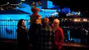 Sejumlah orang berdiri di dekat lampu berwarna biru dinyalakan untuk menandai awal musim Natal di Juzcar, Selatan Spanyol, 2 Desember 2016. Kini desa serba biru tersebut menjadi sangat populer sebagai desa Smurfs bagi wisatawan. (REUTERS/Jon Nazca)