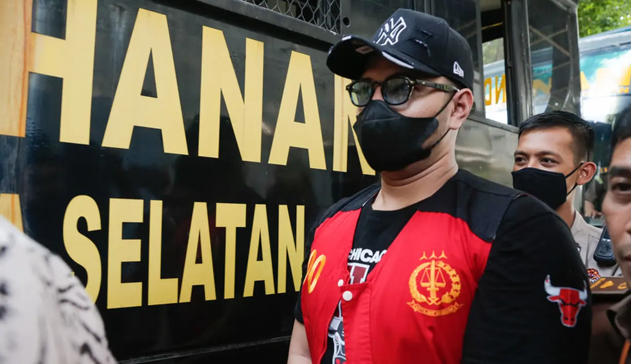 Ammar Zoni turun dari mobil saat tiba di Pengadilan Negeri Jakarta Selatan. Pria berusia 30 tahun itu mengenakan rompi tahanan berjalan masuk ruang sidang. Penampilannya makin lengkap dengan kaca mata, topi dan masker hitam. [Foto: KapanLagi.com/Muhammad Akrom Sukarya]