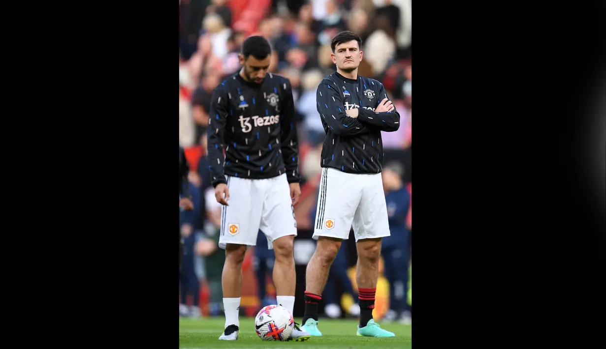 Pemain MU, Harry Maguire (kanan), memantau rekan satu timnya, Bruno Fernandes, dalam sesi latihan sebelum pertandingan partai tunda pekan ke-32 melawan Chelsea yang berlangsung di Old Trafford, Jumat (26/5/2023). (AFP/Oli Scarff)