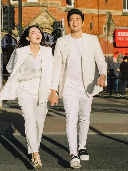 Saat masa bulan madu, pasangan yang menikah pada 15 Juli 2022 ini juga tampil mesra dengan busana bernuansa putih. Keduanya tampak sedang berjalan di jalanan kota Manchester, Inggris. Keduanya memilih honeymoon di Eropa karena klub sepak bola favorit mereka bernaung di sana. (Liputan6.com/IG/@chevra_yo88)