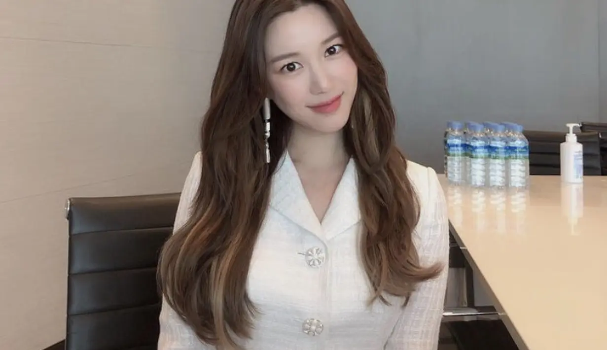 Mengenakan blazer putih, Lee Da In tampil anggun dengan rambut panjang cokelat belah duanya.(@xx__dain)