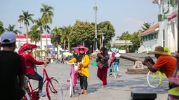 Wisatawan berfoto sambil bermain sepeda di kawasan Museum Fatahillah, Jakarta, Jumat (6/10). Usai revitalisasi kini museum tersebut terlihat lebih bersih dan bebas dari pedagang liar kaki lima. (Liputan6.com/Faizal Fanani)