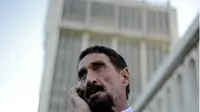 Ahli keamanan siber John McAfee sedang menelepon dengan smartphone-nya (Foto: Mashable)